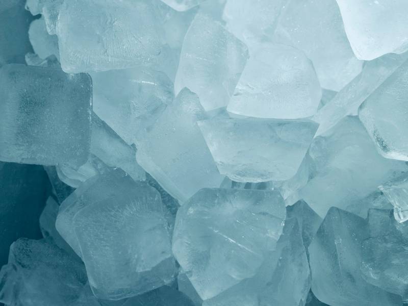 A pile of clear ice cubes with a cool blue tint.